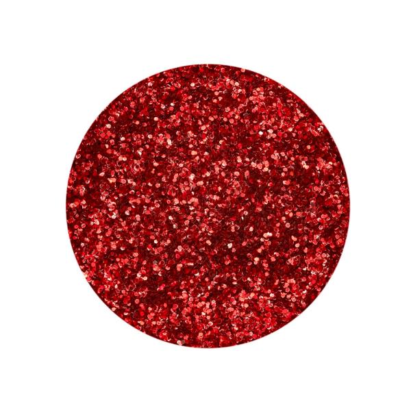 Roter Bio-Glitter, fein gekörnt, schimmert hell auf einer dunklen Oberfläche und ist ideal zum Verzieren von Kerzen geeignet.